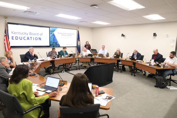 Kentucky Board of Education members sit around a series of tables
