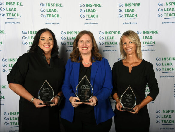 Melanie Howard, Michelle Gross and Kara Byrn Dowdy smile together while holding glass trophies.