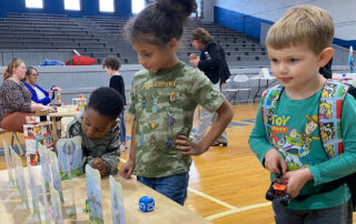 A group of kids play with toys on a table