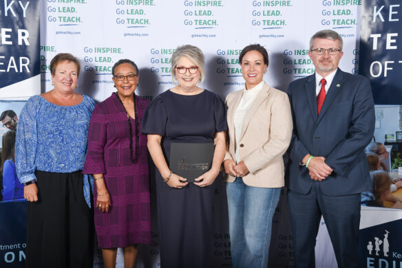From left to right, Lu Young, Sharon Porter Robinson, Jacqueline Coleman and Robbie Fletcher pose for a photo as Coffey holds a black folder with the Kentucky Department of Education logo on it