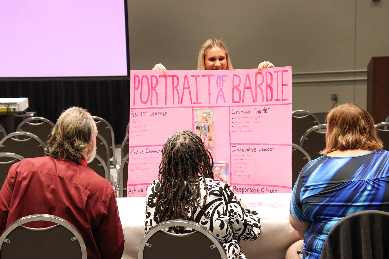 Shelby Sandusky, a junior at Rockcastle County High School, shows her “Portrait of a Barbie” bulletin board project to a panel of judges during the 2026 Kentucky Educators Rising state conference.
