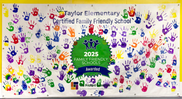 A mural with handprints in different colors and the words "Taylor Elementary Certified Family Friendly School" on it