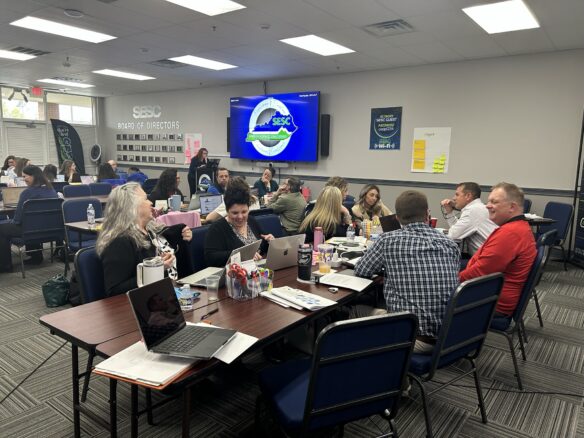 A room of people sitting at tables