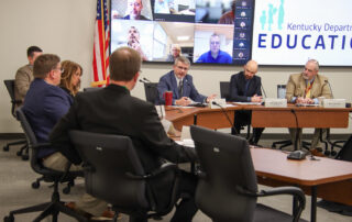Group of people sitting around a table having a discussion.