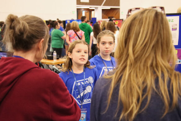 Two girls talk to two judges