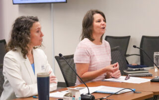 Two women sit at a table and talk