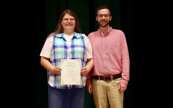 Haley Jones, holding a certificate, stands next to Tyler Saylor.