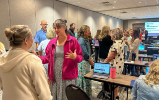 A group of people in a room talk to each other