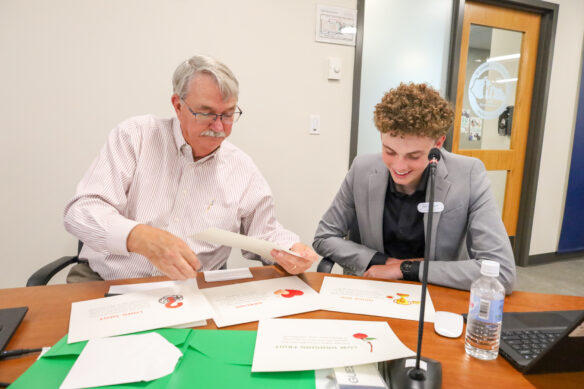 Two board members work on a collaborative project together at a table.