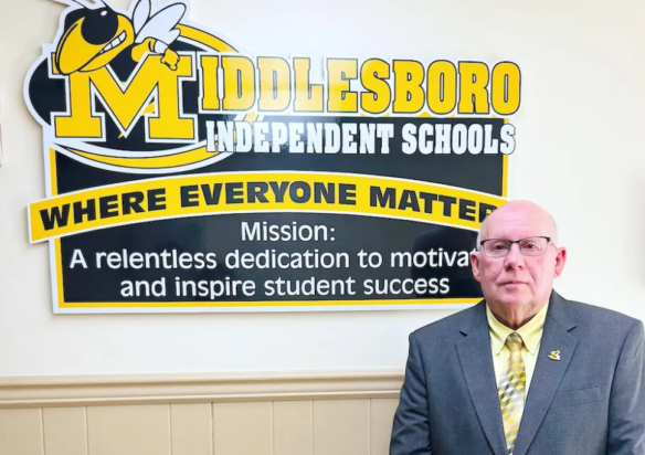 Bill Jones stands in front of a sign showing the name of the district, Middlesboro Independent Schools