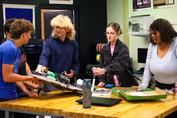 Four Elizabethtown High School (Elizabethtown Independent) students stand around a table with engineering supplies as they work on a group project in Missy Mill’s engineering class.