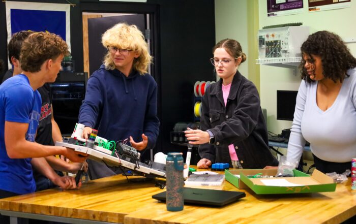 Four Elizabethtown High School (Elizabethtown Independent) students stand around a table with engineering supplies as they work on a group project in Missy Mill’s engineering class.
