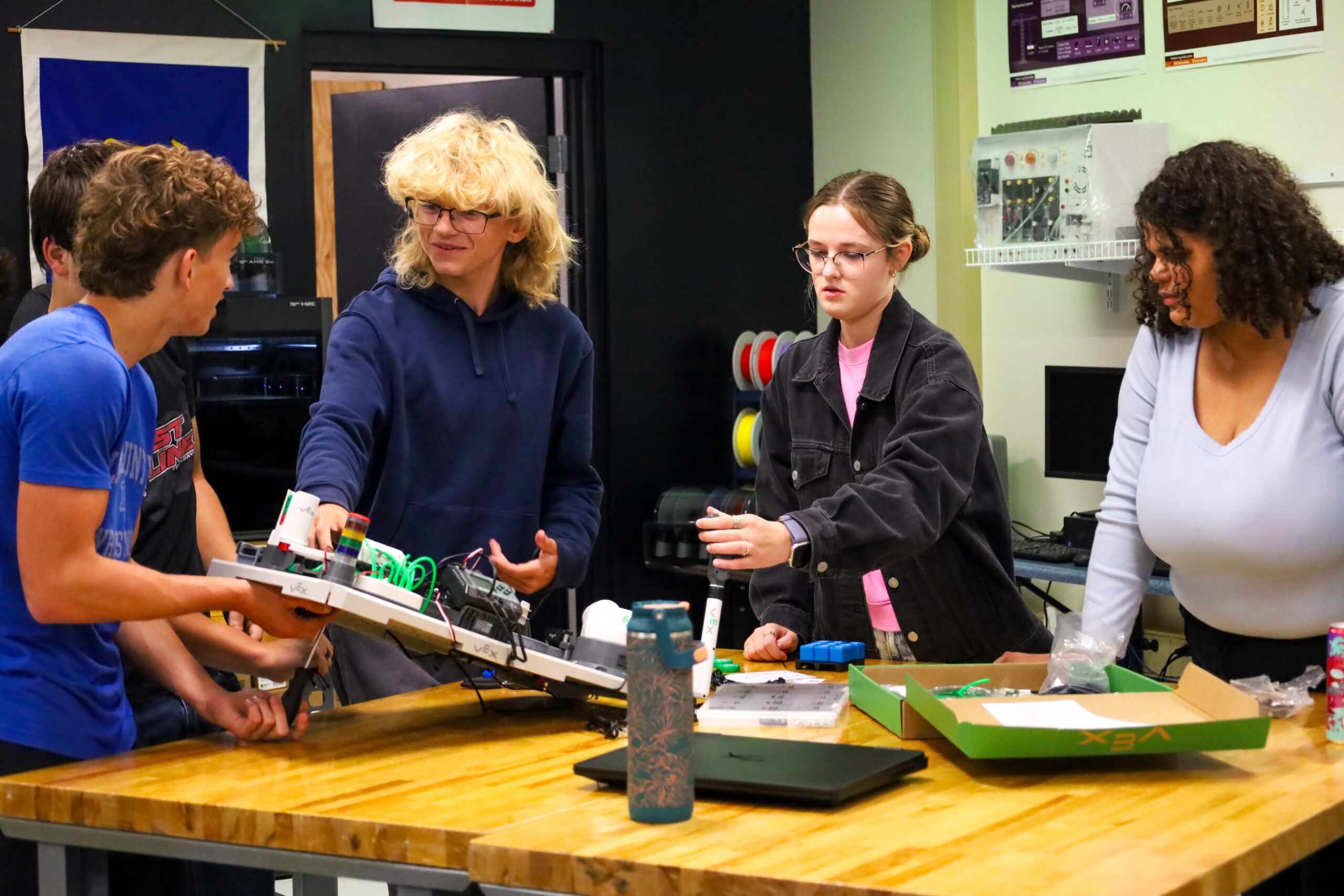 Four Elizabethtown High School (Elizabethtown Independent) students stand around a table with engineering supplies as they work on a group project in Missy Mill’s engineering class.